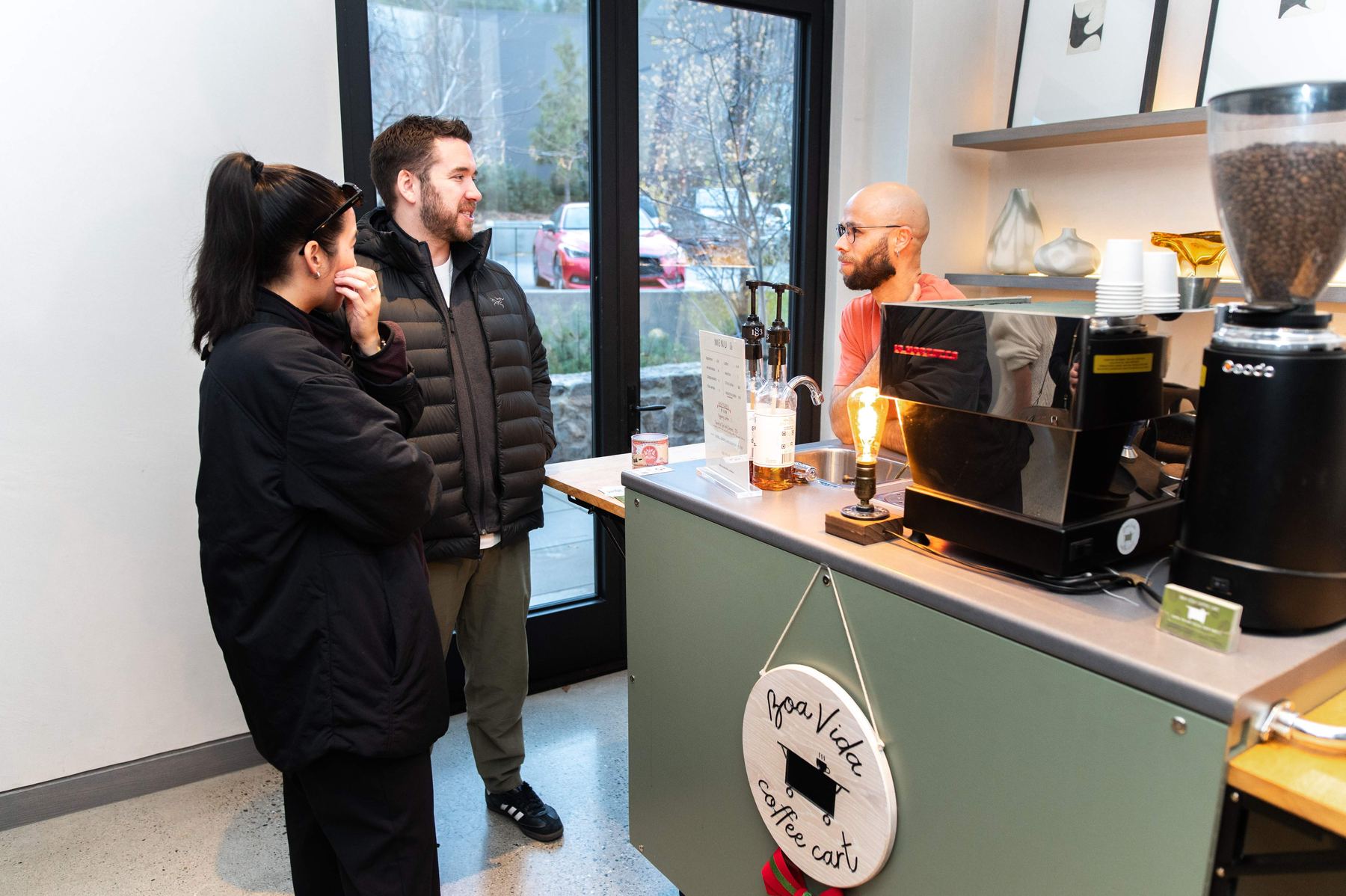 A Boa Vida barista serving coffee to guests from the cart at an event